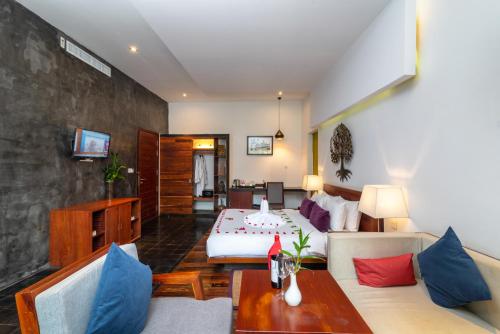 Habitación de hotel con cama y sala de estar. en King Rock Boutique Hotel, en Siem Reap