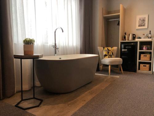 a large bath tub in a bathroom with a chair at Jorvik House in York
