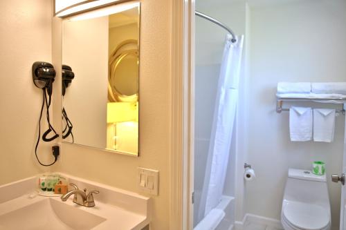 a bathroom with a sink and a mirror and a toilet at Travelodge by Wyndham Crescent City in Crescent City