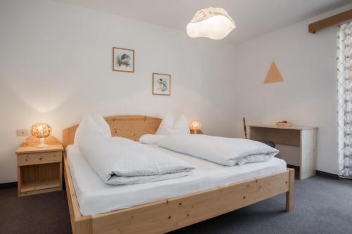 1 Schlafzimmer mit 2 Betten und weißer Bettwäsche in der Unterkunft Hotel Langeshof in Anterivo