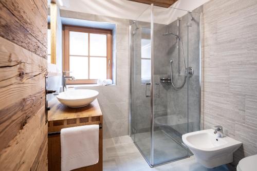 a bathroom with a shower and a sink and a toilet at Loefflerhof in Monguelfo