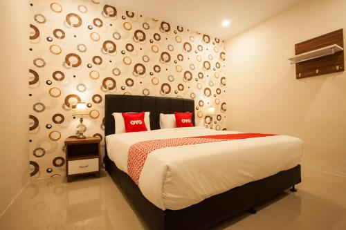 - une chambre avec un grand lit et des oreillers rouges dans l'établissement Residence Anugrah, à Medan