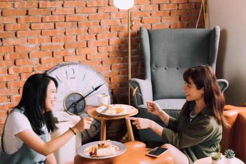 two women sitting at a table eating food at Uno Backpackers Inn in Kaohsiung