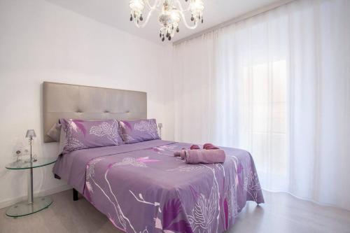 バレンシアにあるApartment Marchalenesのベッドルーム(紫色のベッド1台、シャンデリア付)