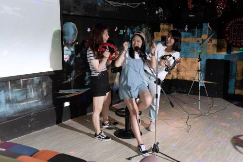 a group of girls on a stage with microphones at Uno Backpackers Inn in Kaohsiung