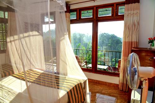a bedroom with a bed and a large window at Senasuma Inn Ella in Ella