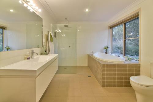 a bathroom with a tub and a sink and a toilet at Lakeview Luxury Retreat in Orange