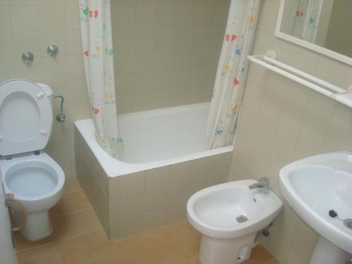 a bathroom with a toilet and a tub and a sink at Menorca Bonavista in Cala Galdana