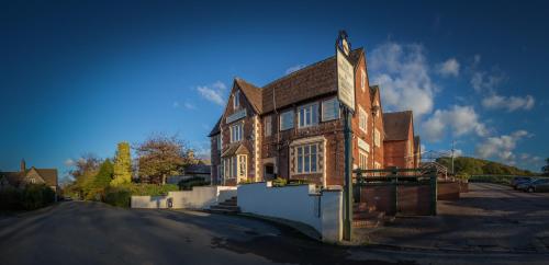 an old brick house on the side of a street at The Beacon & Railway Hotel in Stonehouse