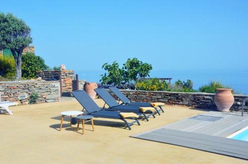 - une rangée de chaises longues à côté de la piscine dans l'établissement Villa Eliza with a swimming pool and sea view in the area of Otzia, on the island of Kea, à Otziás