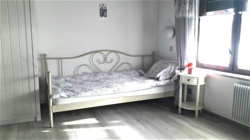 Cama pequeña en habitación con ventana en Family Apartment NAKITEYA en Liubliana