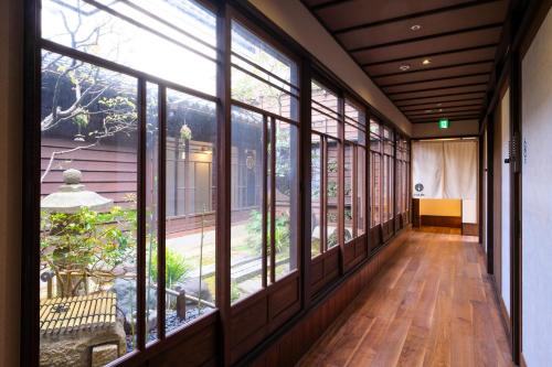an empty hallway with large windows in a house at GUESTHOUSE UMENOYA in Wajima