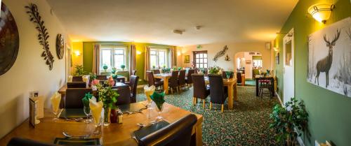a restaurant with tables and chairs in a room at The Beacon & Railway Hotel in Stonehouse
