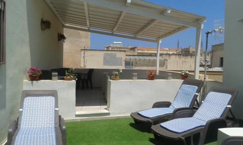 トラーパニにあるSAT Appartamenti Locazioni turistiche brevi-G&P HOLIDAY HOMEの屋上のパティオ(椅子、テーブル付)