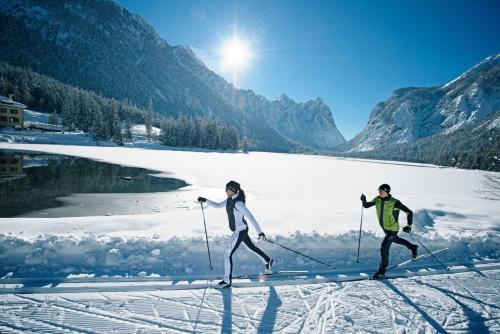 two people are cross country skiing in the snow at Skyview Chalets am Camping Toblacher See in Dobbiaco