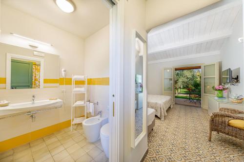 Wine Resort Ledà d'Ittiri في فيرتيليا: حمام مع حوض ومرحاض وحوض استحمام
