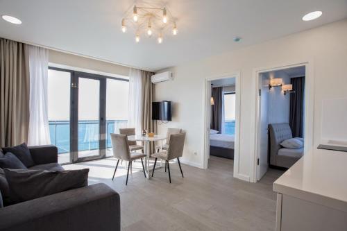 a living room with a couch and a table with chairs at The SPOT apartments - Orbi Beach Tower in Batumi
