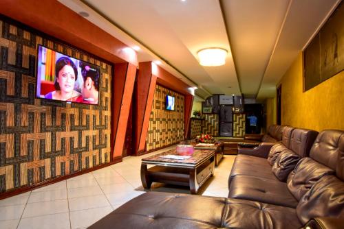 a living room with a couch and a flat screen tv at Hotel OK Kampala in Kampala
