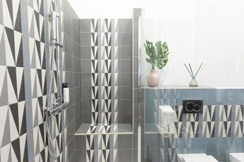 a bathroom with gray and white tiles and a shower at Hotel Miceli - Civico 50 in Florence