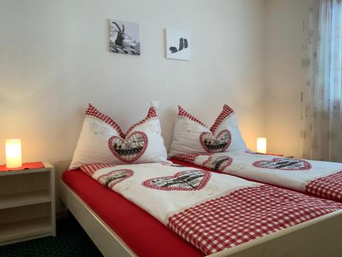 ザース・グルントにあるCasa Stellaのベッドルーム1室(ベッド2台、赤と白の枕付)