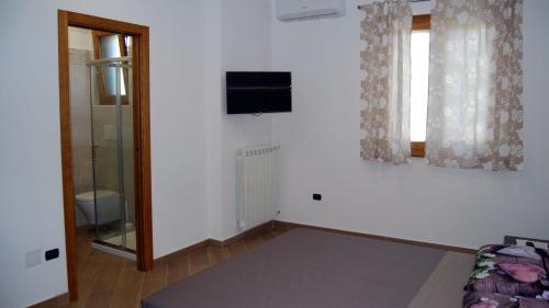 een kamer met een bed en een televisie aan de muur bij Madre Terra in Pimonte