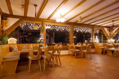 a dining room with tables and chairs and lights at Hotel Berglandstübel in Hammerbrücke
