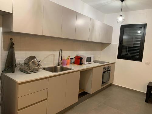 a kitchen with a sink and a microwave at Meir Yaari 20 in Tel Aviv