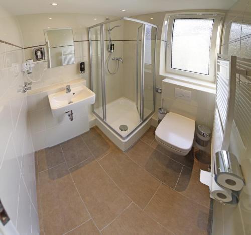 a bathroom with a shower and a sink and a toilet at Hotel Residenz in Düsseldorf