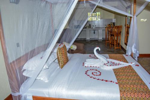 a bedroom with a bed with a bird on it at Mwanzo Lodge in Naivasha