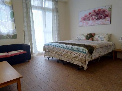 a bedroom with a bed and a couch and a window at Taroko Xincheng Old Street in Xincheng