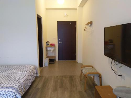 a bedroom with a bed and a flat screen tv at Taroko Xincheng Old Street in Xincheng