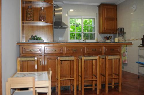 a kitchen with wooden cabinets and a table and a window at Villa Cuesta in O Grove