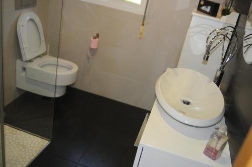 a bathroom with a white toilet and a sink at Villa Cuesta in O Grove