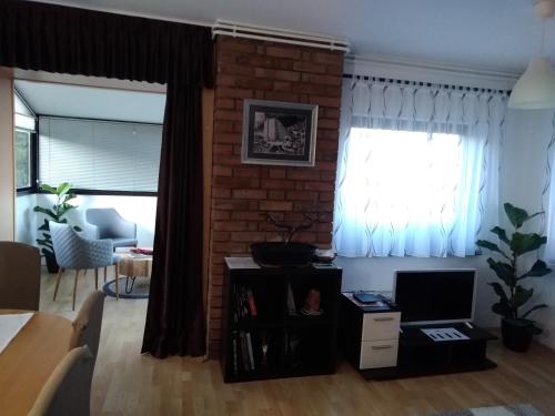 ein Wohnzimmer mit einer Ziegelwand und einem Fenster in der Unterkunft Sunrise Home in Maribor