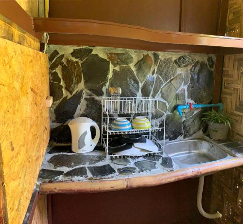 a kitchen counter with a sink and a shelf with dishes at Easylife Bungalow in Ko Lanta