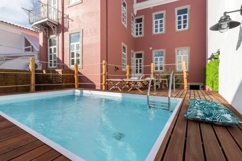 a swimming pool on a deck next to a building at aleixomor'Aqui in Loulé