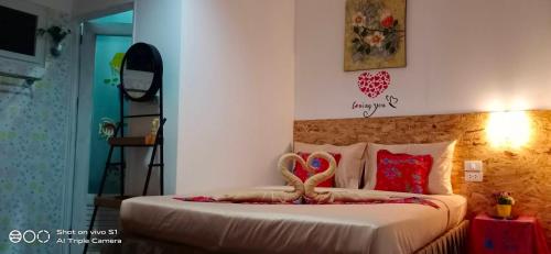 a bedroom with a bed with two swans on it at Decho Hostel in Ko Lipe
