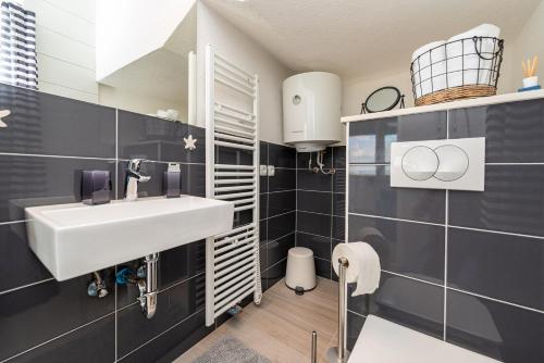 a bathroom with a white sink and blue tiles at Vila Luna Apartments in Zadar
