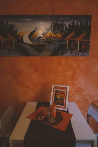 a table with a picture and a painting on the wall at B&B Gli Olmi in Creazzo