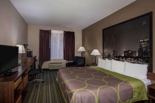 a hotel room with a bed and a desk and a television at Super 8 by Wyndham Union in Union