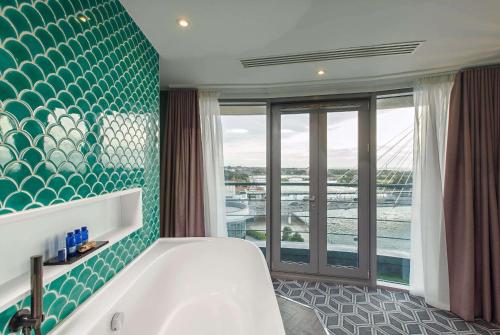 a bathroom with a tub and a large window at Waterfront Southport Hotel in Southport