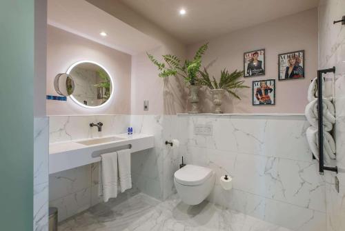 a white bathroom with a toilet and a sink at Waterfront Southport Hotel in Southport