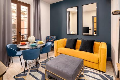 a living room with a yellow couch and a table at SUITE 1907 GIJON in Gijón