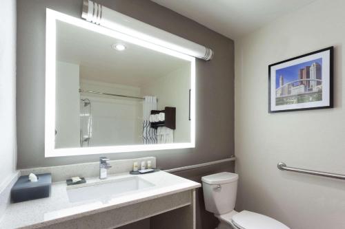 a bathroom with a sink and a toilet and a mirror at La Quinta by Wyndham Columbus West - Hilliard in Columbus