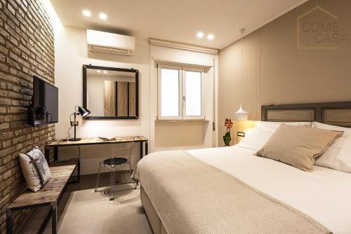 a bedroom with a bed and a desk and a mirror at Come a Casa in Rome