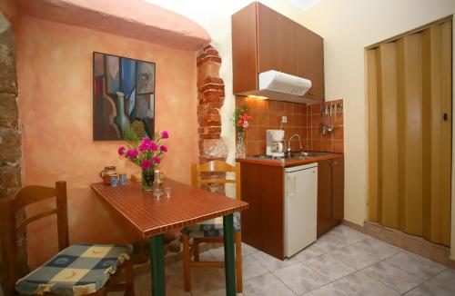 a small kitchen with a wooden table and a sink at Iason Studios in Chania