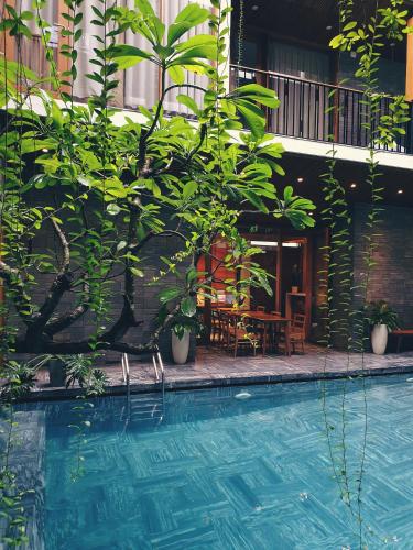 a swimming pool with a table and chairs and plants at Mai's Boutique in Da Nang