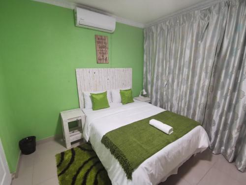 a bedroom with a large bed with green walls at The Zion Hill in East London