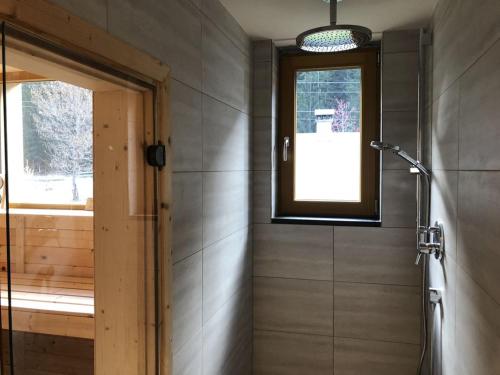 a bathroom with a shower stall and a window at Klösterle 72 -Annas Lodge in Klösterle