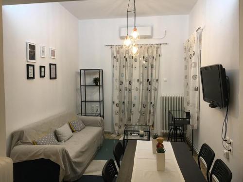 - un salon avec un canapé et une télévision dans l'établissement Plomari - Seafari Apartment, à Plomári